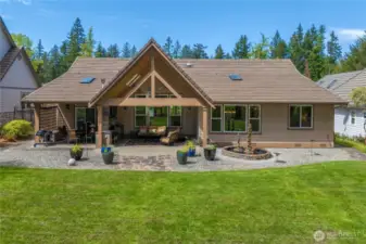 True backyard oasis, ideal for gatherings and relaxation with a spacious patio, built-in fireplace,  TV, heater, and counterspace for outdoor entertainment