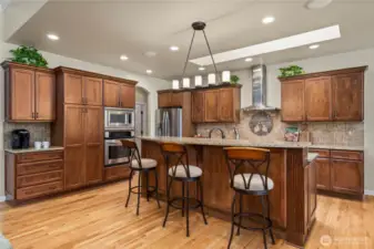 The heart of the home, an inviting kitchen with stunning warm cabinetry and a dining area perfect for hosting dinners or entertaining guests