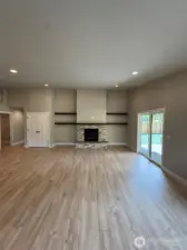 Living room with propane fireplace flanked by wood shelves