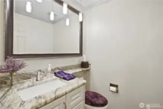 This stylish half bathroom offers functionality with a sleek, modern design. A contemporary vanity with ample counter space is complemented by elegant fixtures and refined lighting.