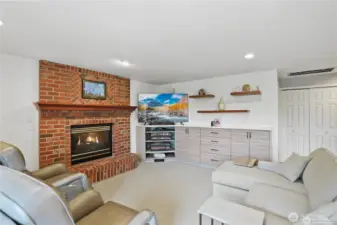 Designed for effortless flow between spaces, this inviting living area extends naturally from the kitchen, creating a central hub for gathering and entertaining. Large windows flood the space with natural light, complementing the neutral tones and refined finishes. A gas fireplace serves as a warm focal point, while custom built-ins provide stylish storage and display options. The open layout ensures flexibility for seating arrangements, making this a perfect space for casual lounging, conversation, and everyday living.
