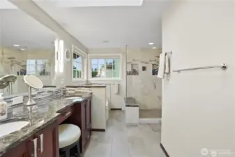 This sophisticated primary suite bathroom boasts a spacious layout with sleek, high-end finishes. A beautifully designed vanity offers ample storage and counter space, complemented by stylish lighting fixtures that enhance the warm, inviting ambiance. The walk-in shower features premium tile work and modern glass enclosure, while a relaxing soaking tub provides the perfect retreat for unwinding. Thoughtful details, including polished hardware and refined accents, create a spa-like experience that balances comfort and elegance.