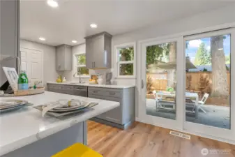 Sliding doors lead to a large, fenced backyard, ideal for entertaining, gardening, or relaxing.