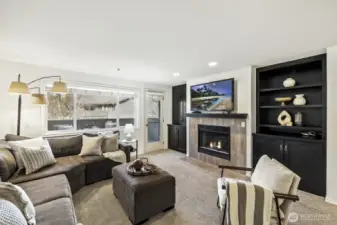 Welcome Home! Relax in your light-filled Living Room with Cozy Fireplace and Custom Cabinetry