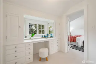 Walk-in closet/room off the primary suite with a built-in desk with drawers and two additional closets, which opens directly to the immaculately maintained and updated bathroom.