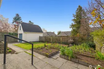 Spacious backyard accessed through French doors from the sunroom, offering plenty of room to garden in the raised flower and vegetable beds.