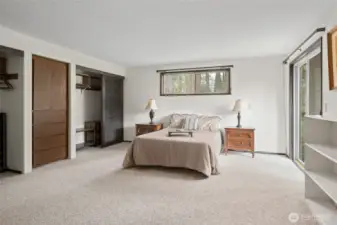 Primary bedroom with two closets and built in shelves and drawers between them.