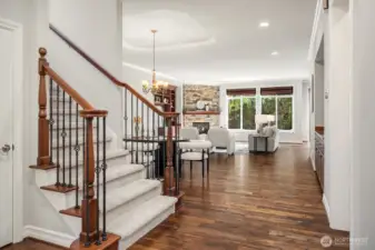The beautifully crafted staircase with rich wood treads and classic white risers anchors the main level, leading the eye through to the open and light-filled great room beyond. Gleaming acacia hardwoods flow seamlessly throughout, highlighting the home's timeless craftsmanship and thoughtful, open layout.