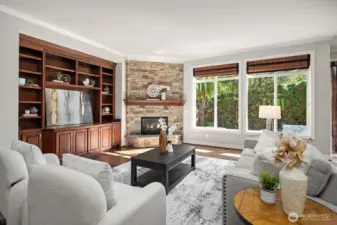 The spacious great room is a warm and inviting retreat, anchored by a classic fireplace with stone surround and flanked by rich built-in cabinetry and shelving. Large windows frame serene views of the private backyard, creating the perfect balance of comfort and elegance for everyday living and entertaining.