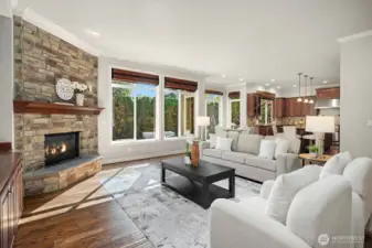 This stunning alternate view of the great room showcases the seamless connection to the outdoors, with expansive glass doors opening directly to the private patio and backyard. The gorgeous stacked stone fireplace, soaring ceilings, and abundant natural light make this space as functional as it is breathtaking.