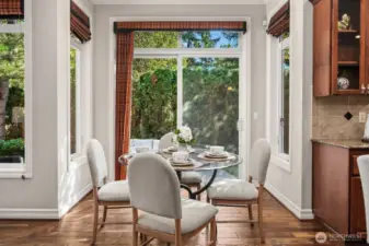 The sun-drenched breakfast nook is a charming and intimate space, framed by large windows that flood the area with natural light and offer peaceful views of the lush backyard. Elegant window treatments and warm hardwood floors make this the perfect spot for casual morning meals or a quiet afternoon retreat.