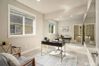 This bright and welcoming bedroom offers the perfect private retreat for guests or multigenerational living, featuring large windows, a dedicated workspace, and a light-filled, airy atmosphere that feels both comfortable and refined. The direct access to a private ensuite bath adds an exceptional level of privacy and convenience for occupants of this thoughtfully designed room.