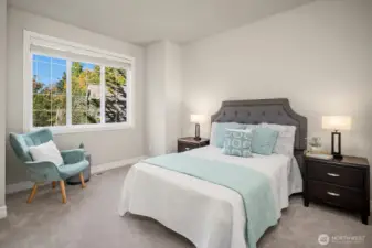 Another generously sized secondary bedroom continues the home's tradition of quality and comfort, with large windows framing beautiful views of the surrounding greenery and filling the space with warm, natural light. Plush carpeting and a soothing neutral palette make this a versatile and inviting room ready to adapt to any need or personal style.