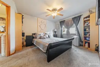 Spacious primary suite with ceiling fan and walk-in closet off the ensuite bathroom.