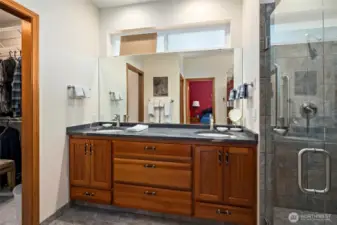 Primary bathroom with a dual sink vanity and large walk-in closet.