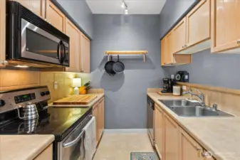 Bright kitchen workspace includes a double-basin stainless steel sink and generous counter space for meal preparation.