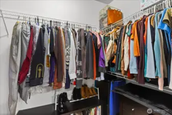 A generously sized walk-in closet provides abundant hanging space and built-in shelving for organization.