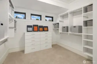 Dreamy walk-in closet infused with natural light from privacy windows.