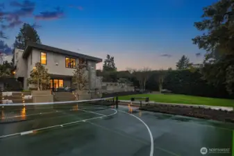Fully lit athletic court with basketball hoop.