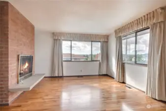 Living room with wood burning fireplace. Nice and bright in here.