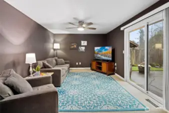 Family room with ceiling fan and slider