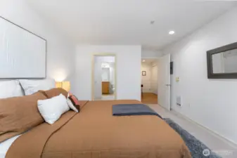 This is a great shot of the good sized primary bedroom, as we look through to the large walk-in closet and en-suite bath. Through the door on the right you'll see the front door and hallway.