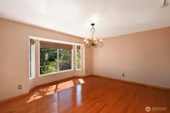 Large dining room bathed in dappled sunlight with a deck out front to appreciate this peaceful setting. Beautiful hardwoods in the main rooms except the living room which is carpeted.