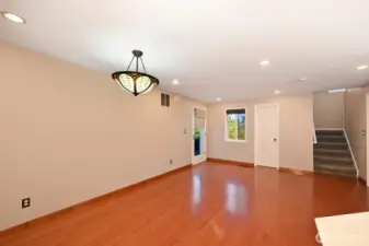Door to the back patio and yard, half bath behind white door, stairs up to four bedrooms and stairs down to the lower level.