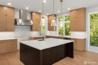 Oversized center island with designer slab counters, Custom built to the ceiling oak cabinets