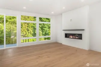 Living space flooded with natural light through floor to ceiling windows and 10 foot ceilings connected to outdoor living on greenbelt backing deck