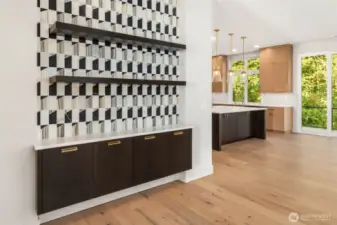 Custom floating cabinets with full height designer selected tile and floating shelves flank dedicated dining space