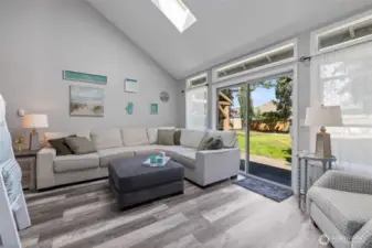 Sunken living room houses vaulted ceilings, skylights,  & patio access!