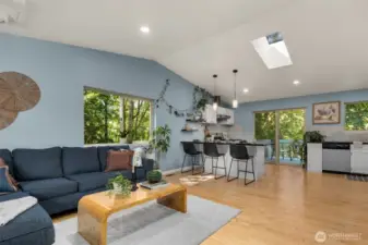 Walk in to an open floor plan with a light-filled spacious living room, beautiful light oak floors, and green space right outside your door.
