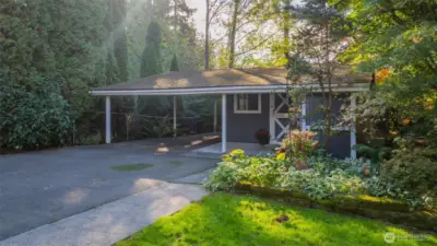Picturesque "barn" with 2 car, covered carport, ample indoor storage & a carpeted, work-from-home office space.