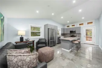 Inside the home, you’ll find superior finishes  throughout including porcelain flooring, glass  tile, hydronic heat, and custom cabinetry. On the  upper level, an open floorplan greets you with a  combined kitchen/dining and living area. The kitchen  offers a huge island with barstool seating, quartz  countertops, and stainless steel appliances for a  stylish setting any chef would love.