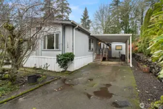 Covered Carport with paved driveway and side entry to the home.