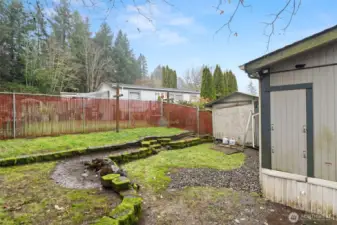 fully fenced backyard with storage shed