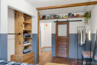 The seller added an opening into the bathroom creating an en suite bath and added a vintage door on a barn slider track.