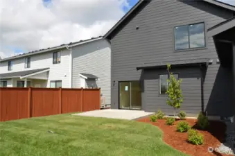 Fenced backyard and patio for main dwelling.