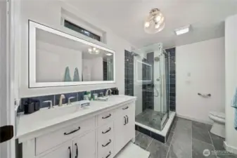 Primary bath with double sink and gorgeous tile shower.