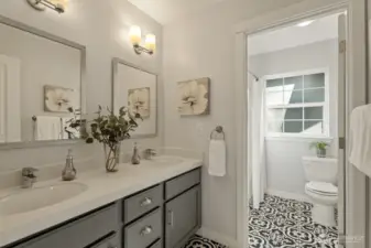 Stylish secondary bathroom with dual sinks, designer tiles, and a private toilet area enhanced by natural light for bright, uplifting mornings.