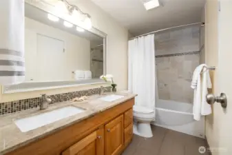 The bathroom has lovely tile throughout along with double vanity sinks. It also has direct access to the primary bedroom.