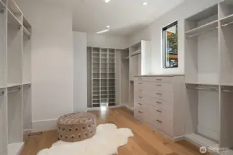 Elegant walk-in closet with custom cabinetry and abundant space for wardrobe and accessories.