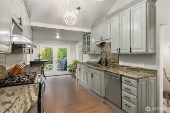 The beautifully appointed chef's kitchen showcases freshly painted cabinetry in a soft sage green that is both 'on trend' and harmonizes with the outdoor spaces.