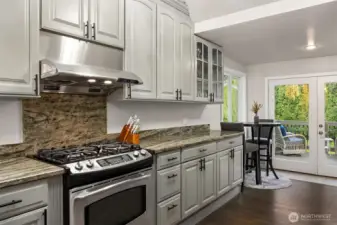Rich granite countertops and backsplash are both modern and timeless. Room for kitchen eating or coffee/tea space.