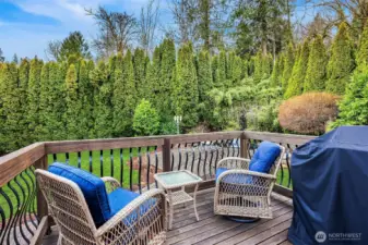 The deck off of the kitchen overlooks the private and lush garden spaces and koi pond.