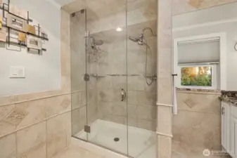 A sumptuous shower with double faucets and full tile surround.
