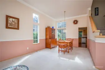 Formal living/dining room has tall ceiling, crown molding & chair rail details