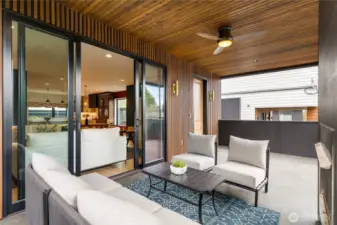 Covered exterior conversation space. Custom overhead lighting and fan.