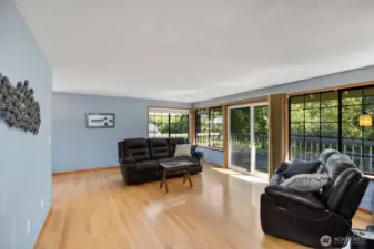 Enter the spacious living room, featuring a sliding glass door that opens to the wraparound deck.